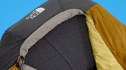 Close-up of a black, gray, and mustard yellow North Face sleeping bag with a drawstring hood.