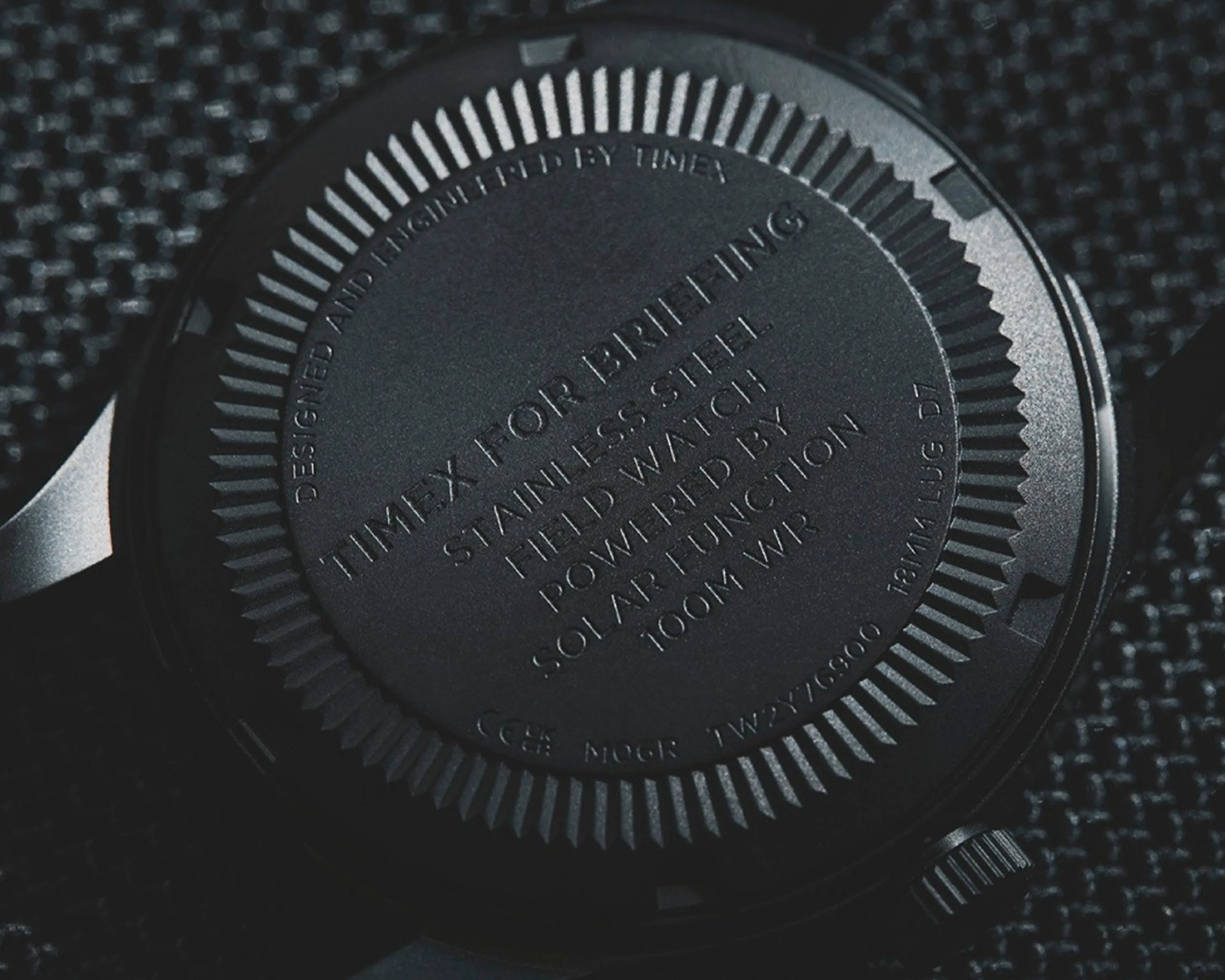 Close-up of the black stainless steel back of a Timex for Breitling solar-powered field watch with engraved text.