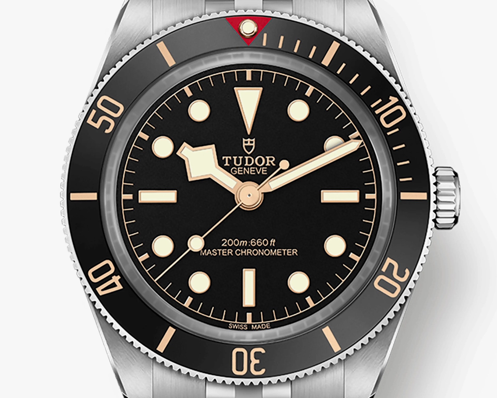 Close-up of a Tudor Black Bay dive watch with black dial, beige markers, and stainless steel bezel and bracelet.