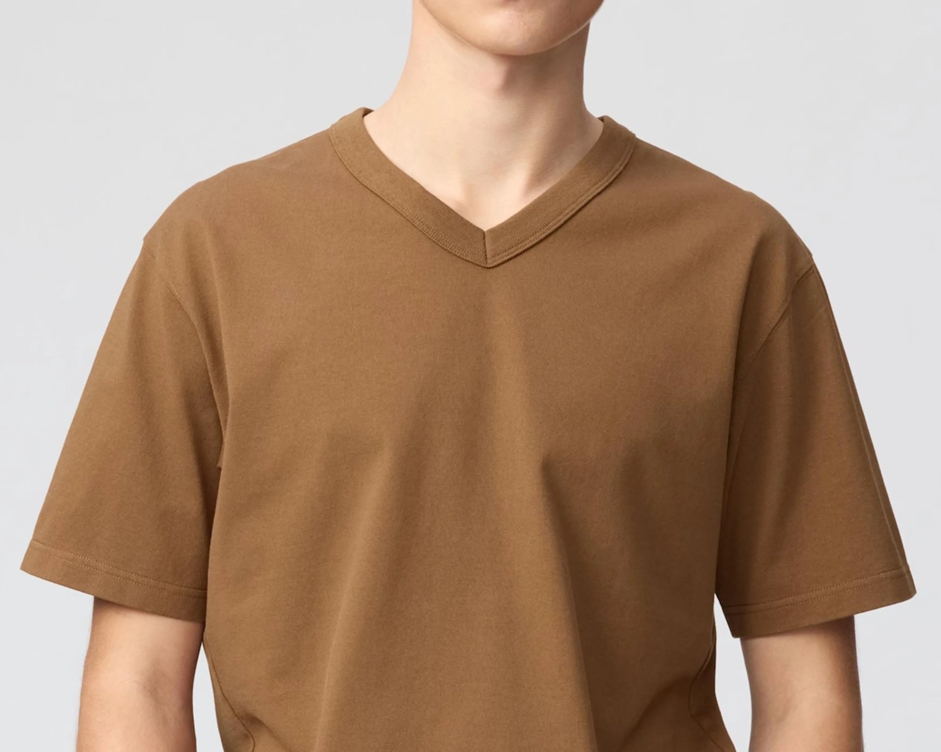 Brown V-neck short-sleeve T-shirt worn by a person against a plain background.