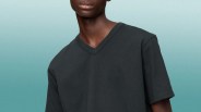 Black V-neck short-sleeve T-shirt worn by a person against a gradient blue background.