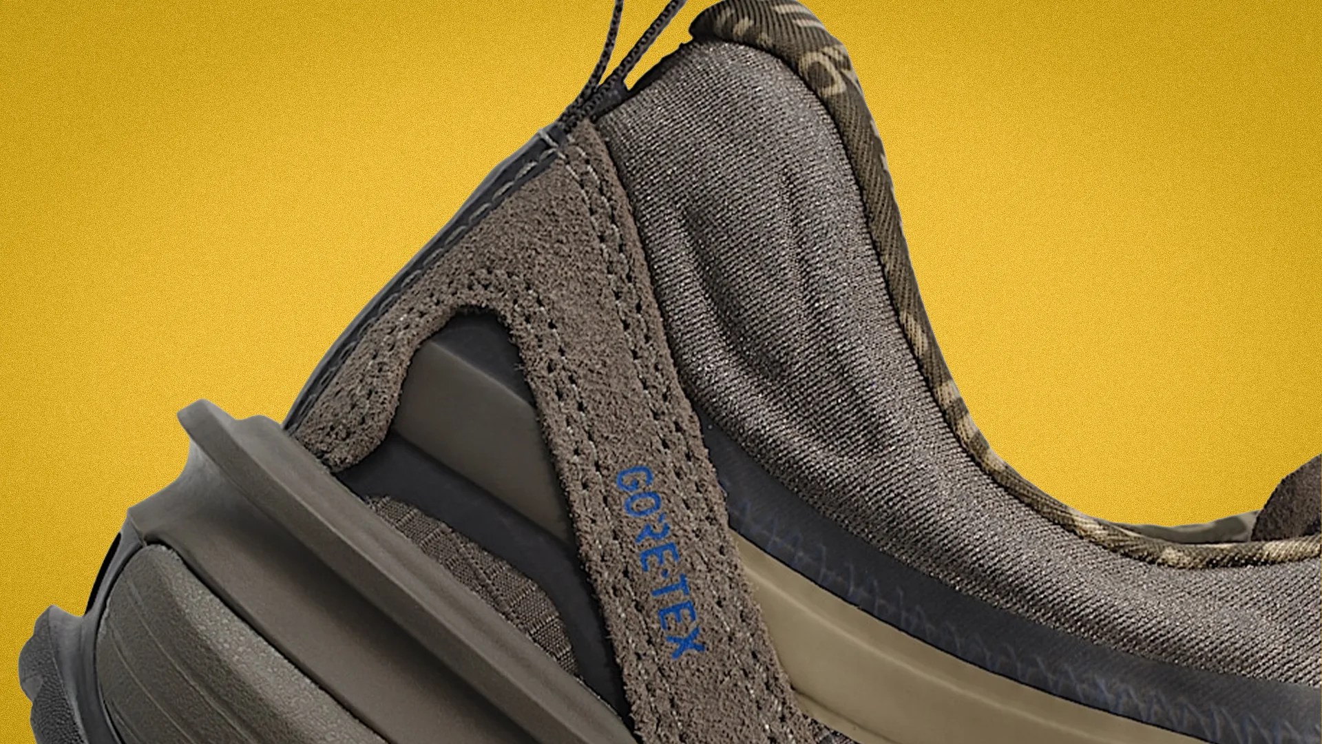 Close-up of a brown Gore-Tex sneaker heel with suede and fabric materials against a yellow background.