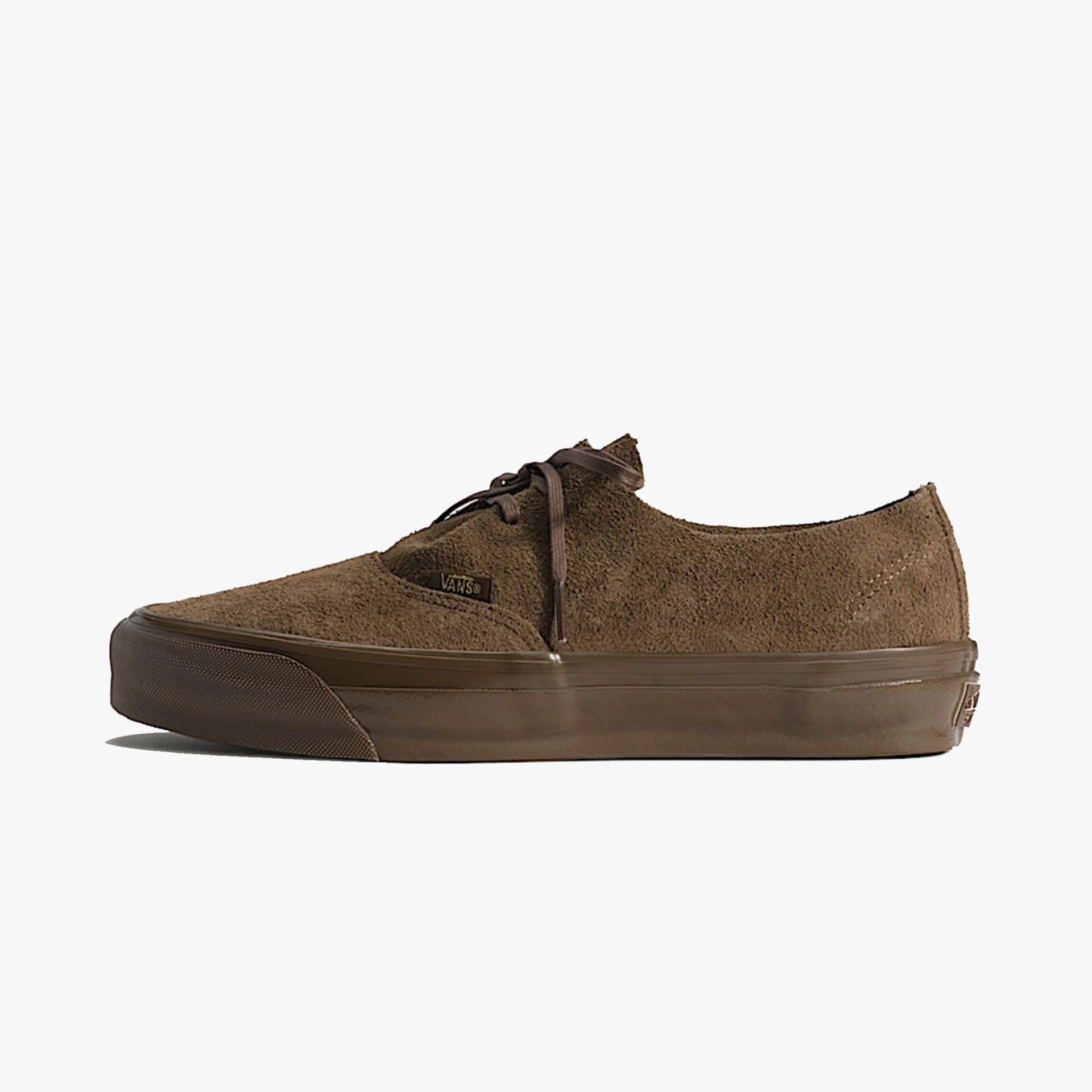 Brown suede Vans sneaker with brown rubber sole and laces, side view.