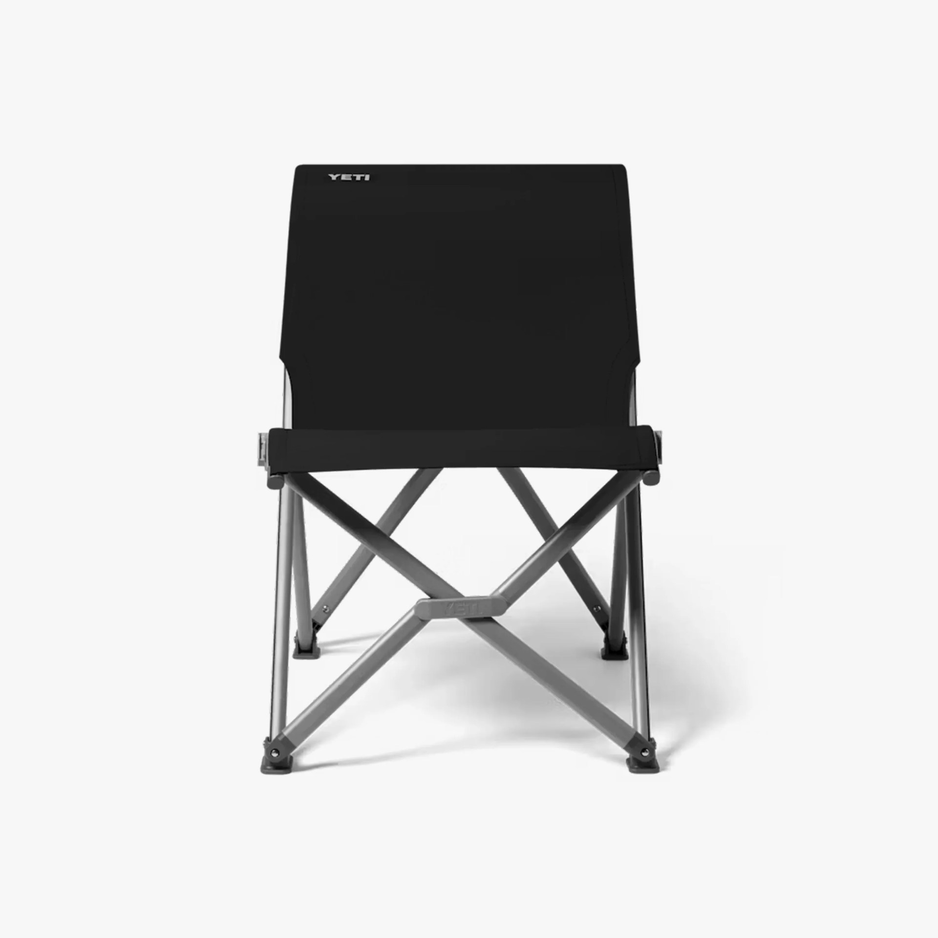 Black YETI low-profile folding camp chair with silver metal frame on a white background.