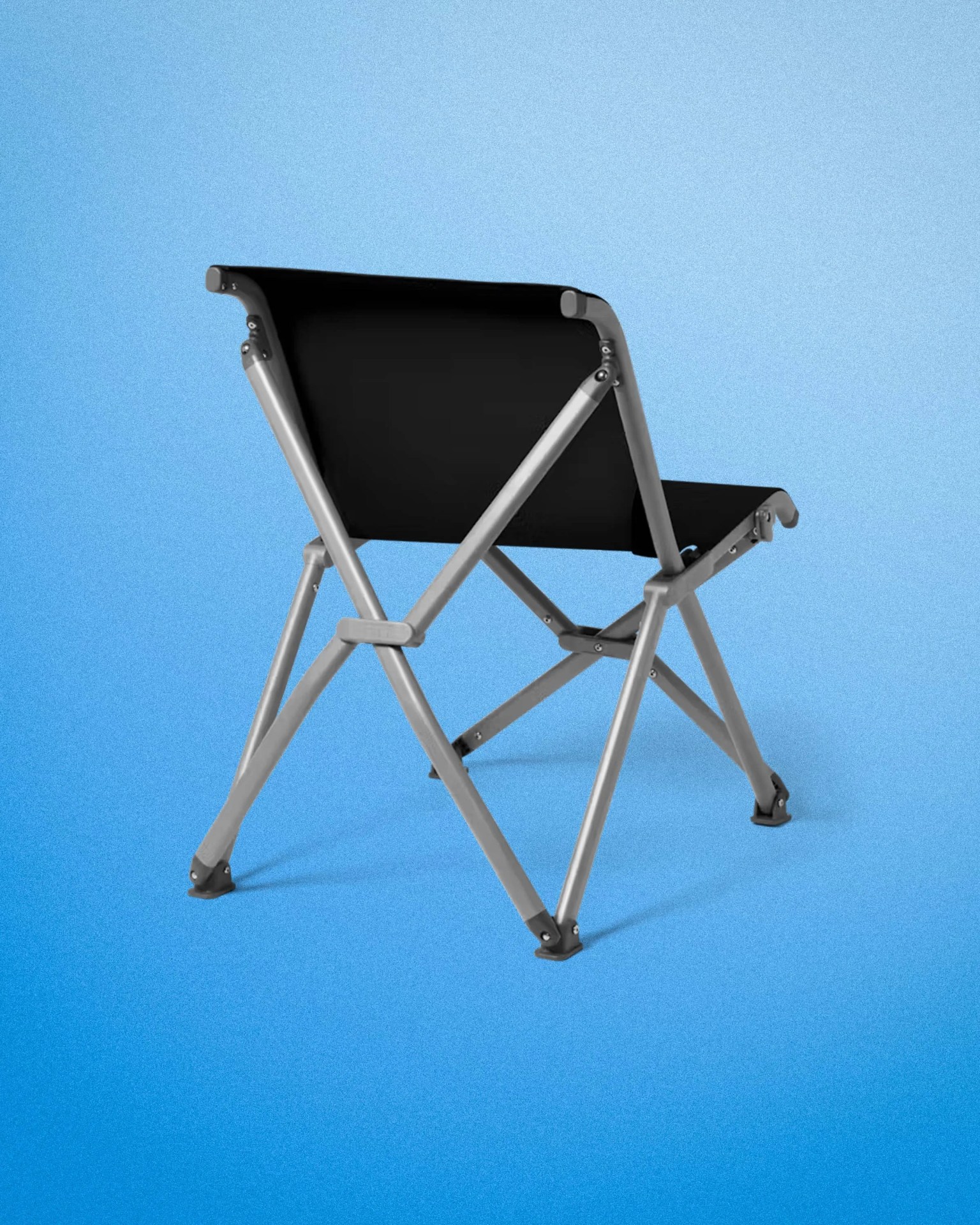 Black fabric folding chair with silver metal frame on a blue gradient background.