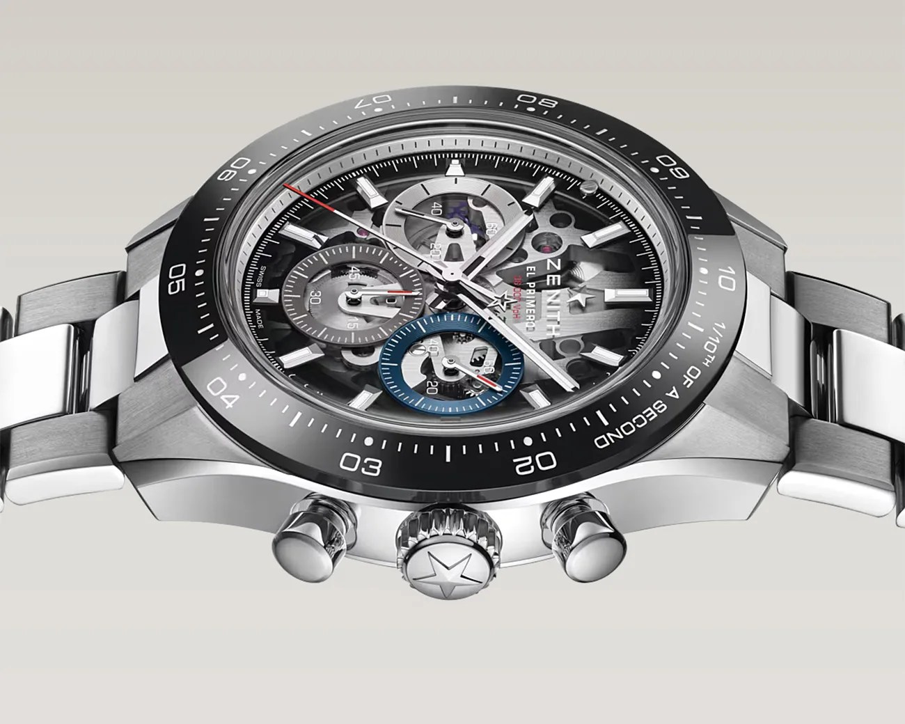Silver Zenith El Primero chronograph watch with black bezel and skeleton dial showing internal gears.