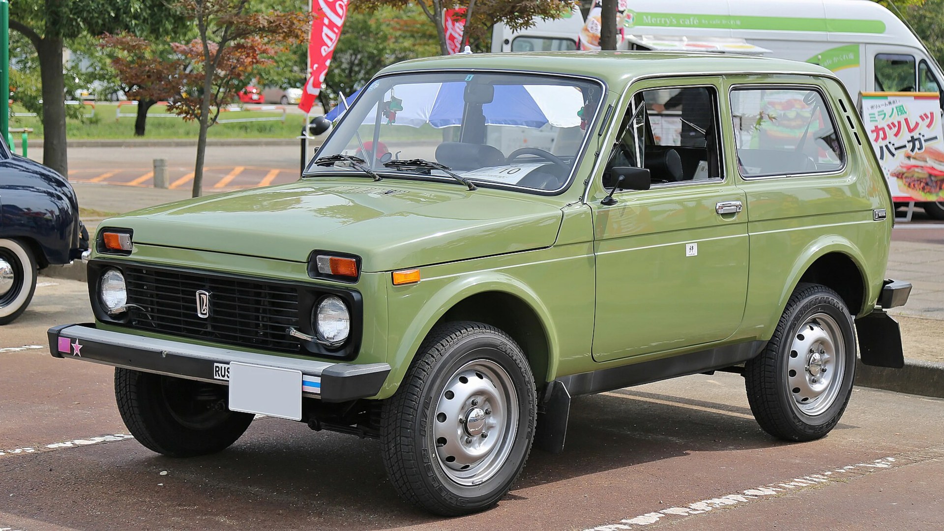 Light green Lada Niva 4x4 SUV parked outdoors with visible front and side details.