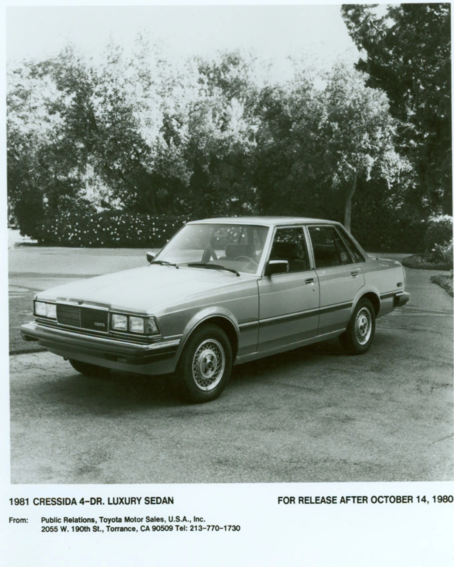 1981 silver Toyota Cressida 4-door luxury sedan parked on a driveway with trees in the background.