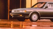 Silver Toyota sedan front side with classic rectangular headlights and detailed wheel covers.