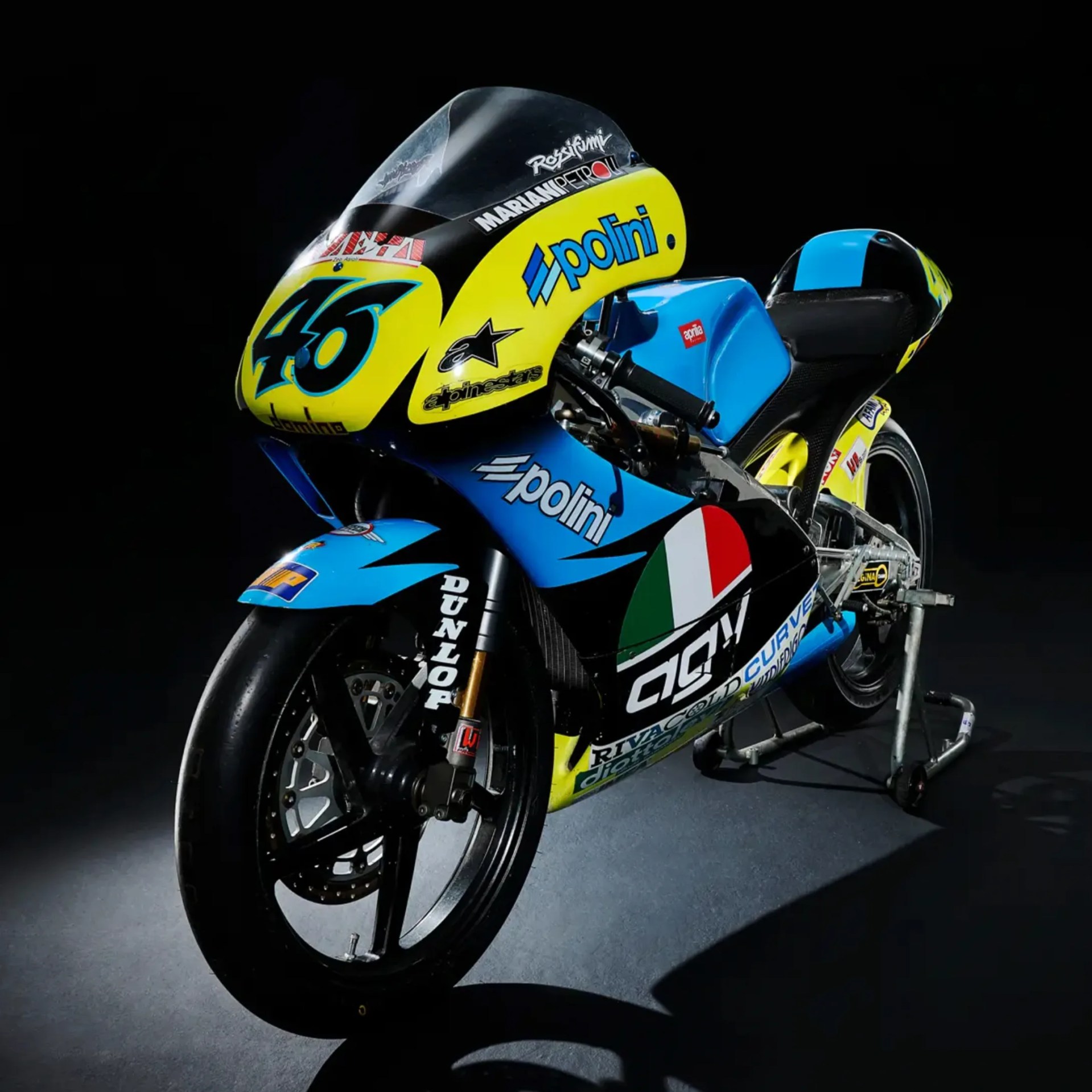 Blue and yellow racing motorcycle with number 46 and Polini branding on a stand.