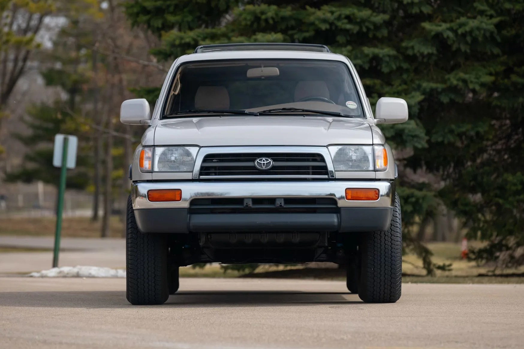 Front view of a silver Toyota SUV with chrome bumper and black grille parked outdoors.