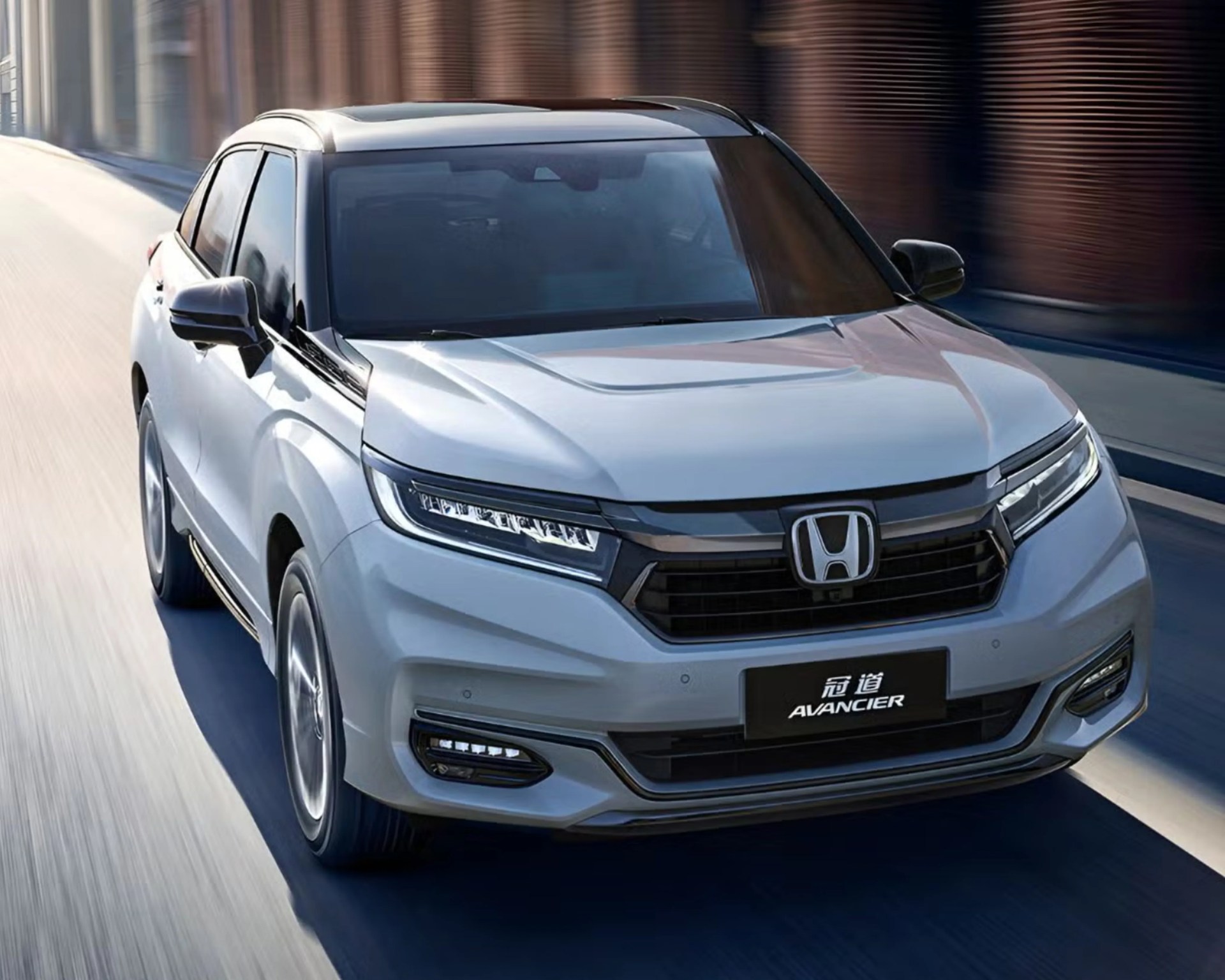 Silver Honda Avancier SUV driving on a city street with black grille and LED headlights.