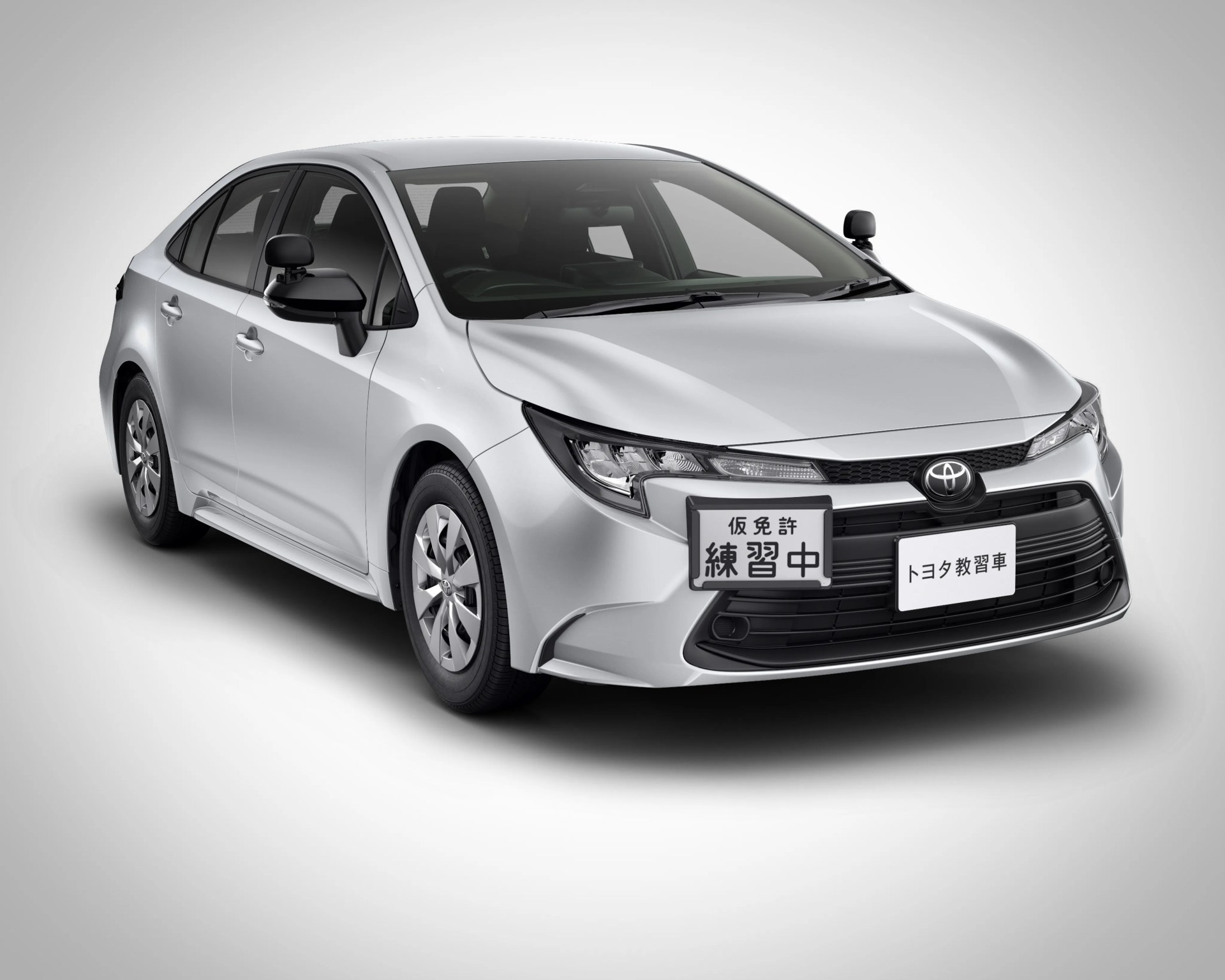 Silver Toyota sedan with black side mirrors and Japanese text on front license plates.