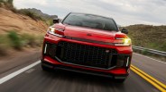 Red Toyota SUV with black grille and GR badge driving on a winding road with desert landscape.