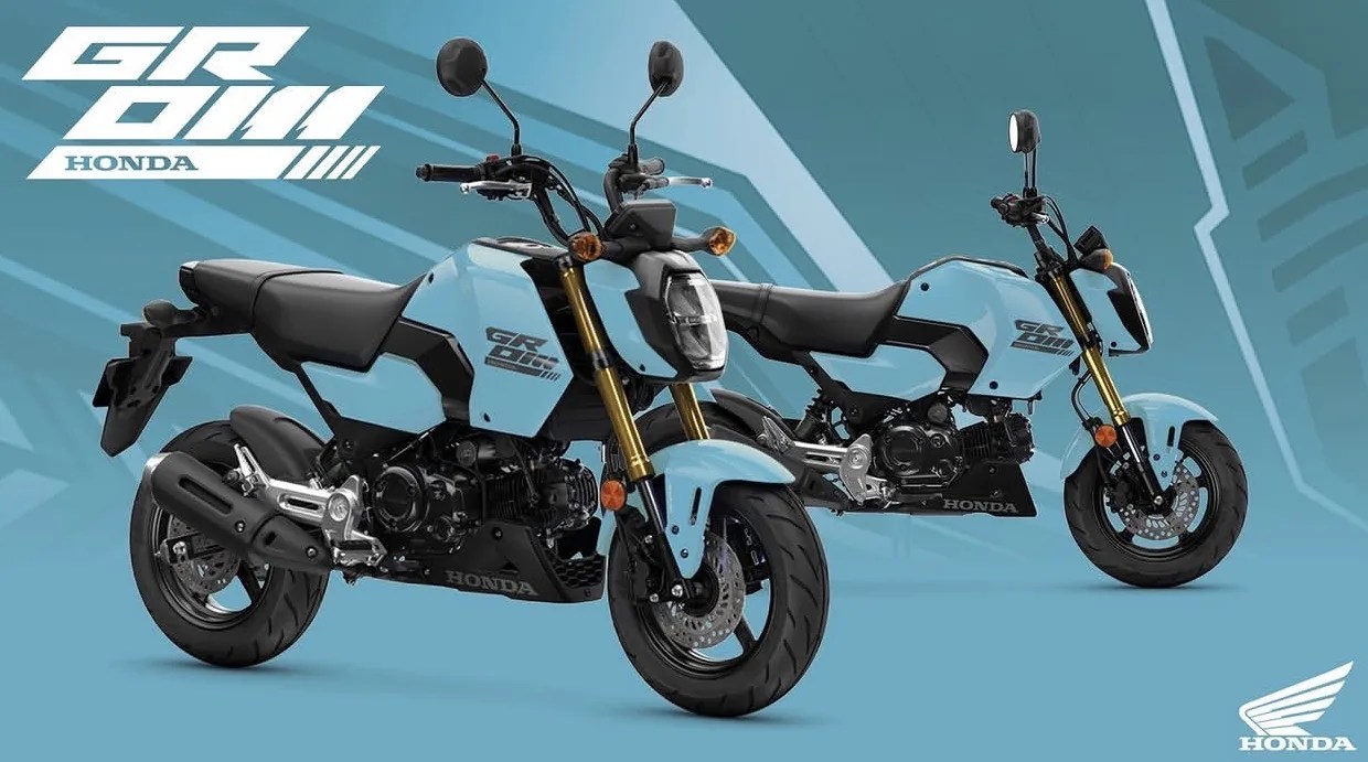 Two light blue Honda Grom motorcycles with black seats and gold front forks on a matching blue background.