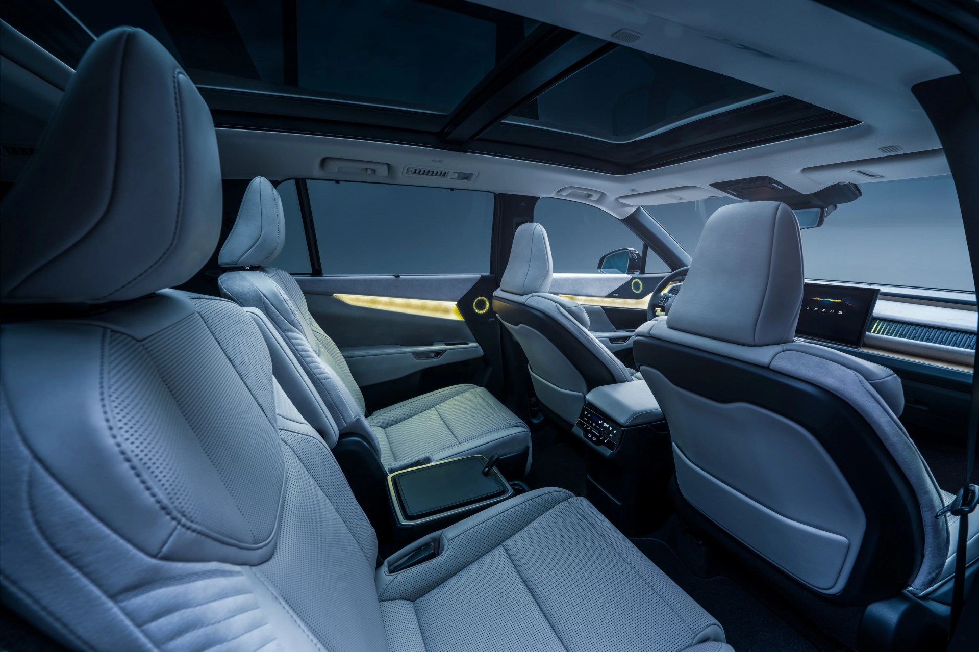 Interior of a car with light gray leather seats, illuminated door panels, and a panoramic sunroof.