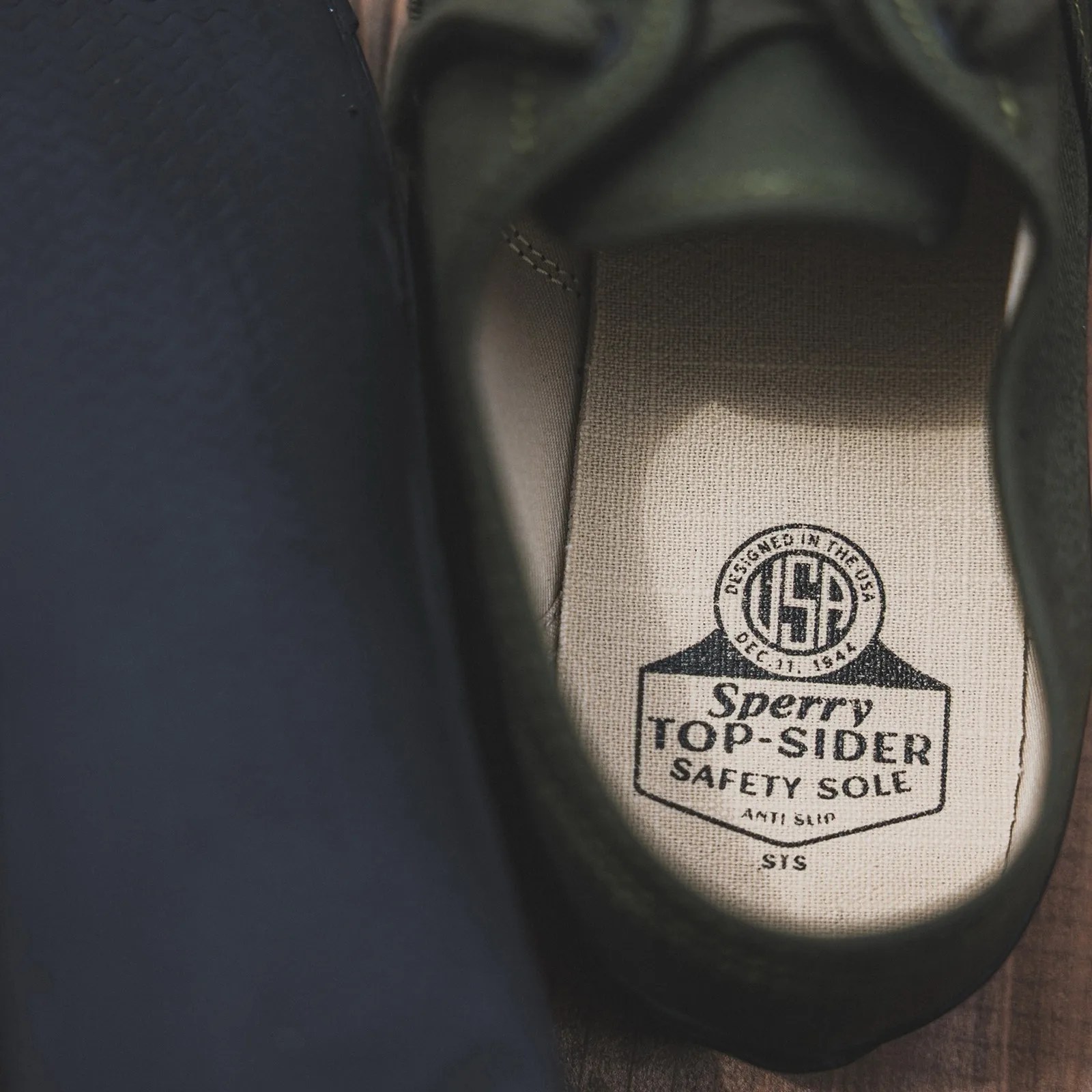 Close-up of the inside sole of a Sperry Top-Sider shoe with "Safety Sole" and "Designed in the USA" text.