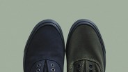 Pair of canvas shoes with black rubber toe caps, one navy blue and one olive green, on a light green background.