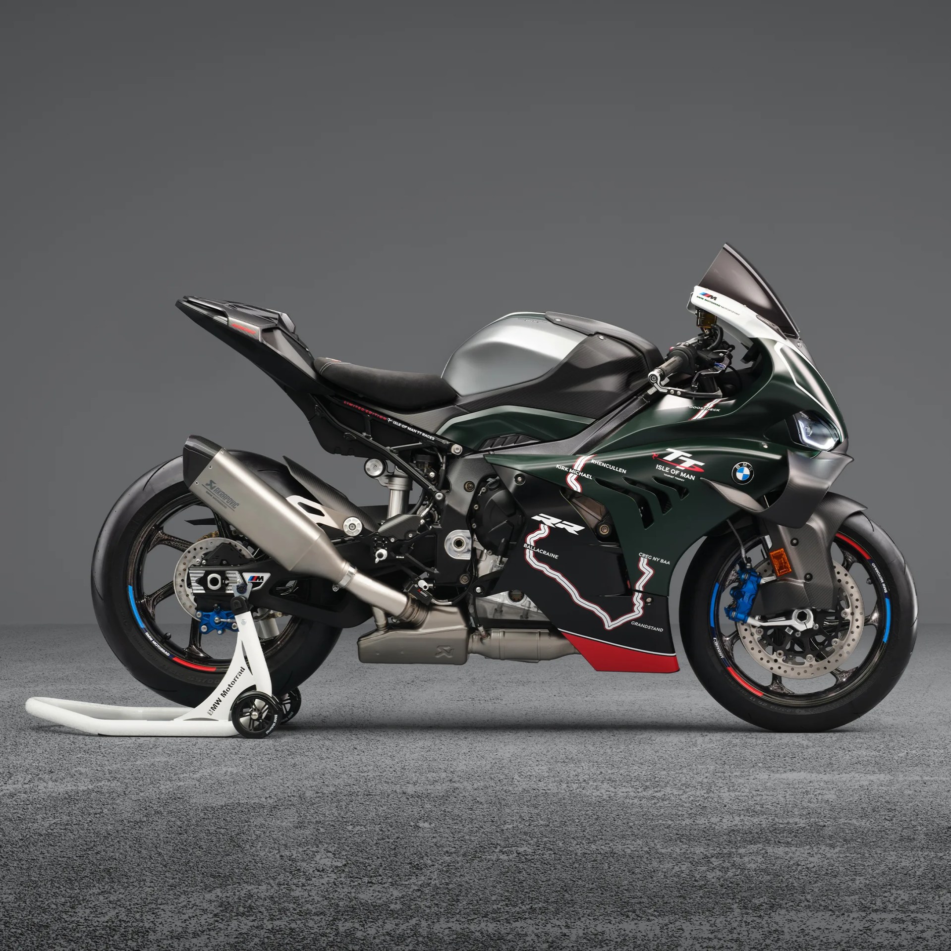 Dark green BMW sport motorcycle with silver exhaust and Isle of Man TT race map decal on fairing.