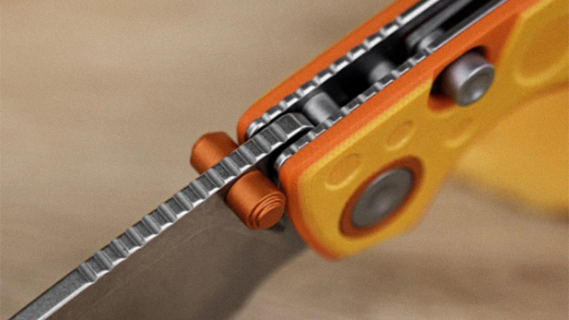 Close-up of a serrated knife blade with an orange and yellow handle and metal rivets.