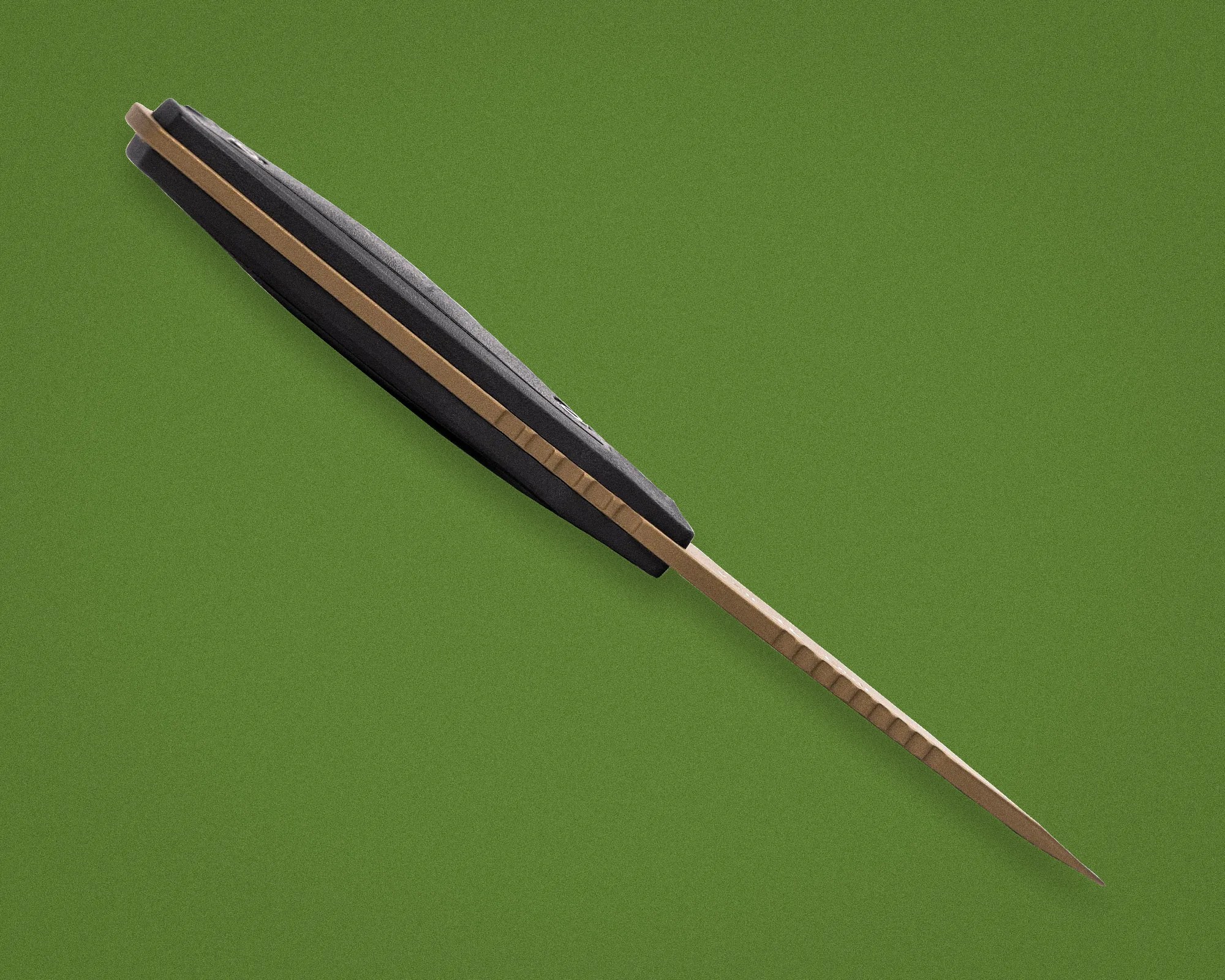 Black and tan folding knife with a textured handle on a green background.