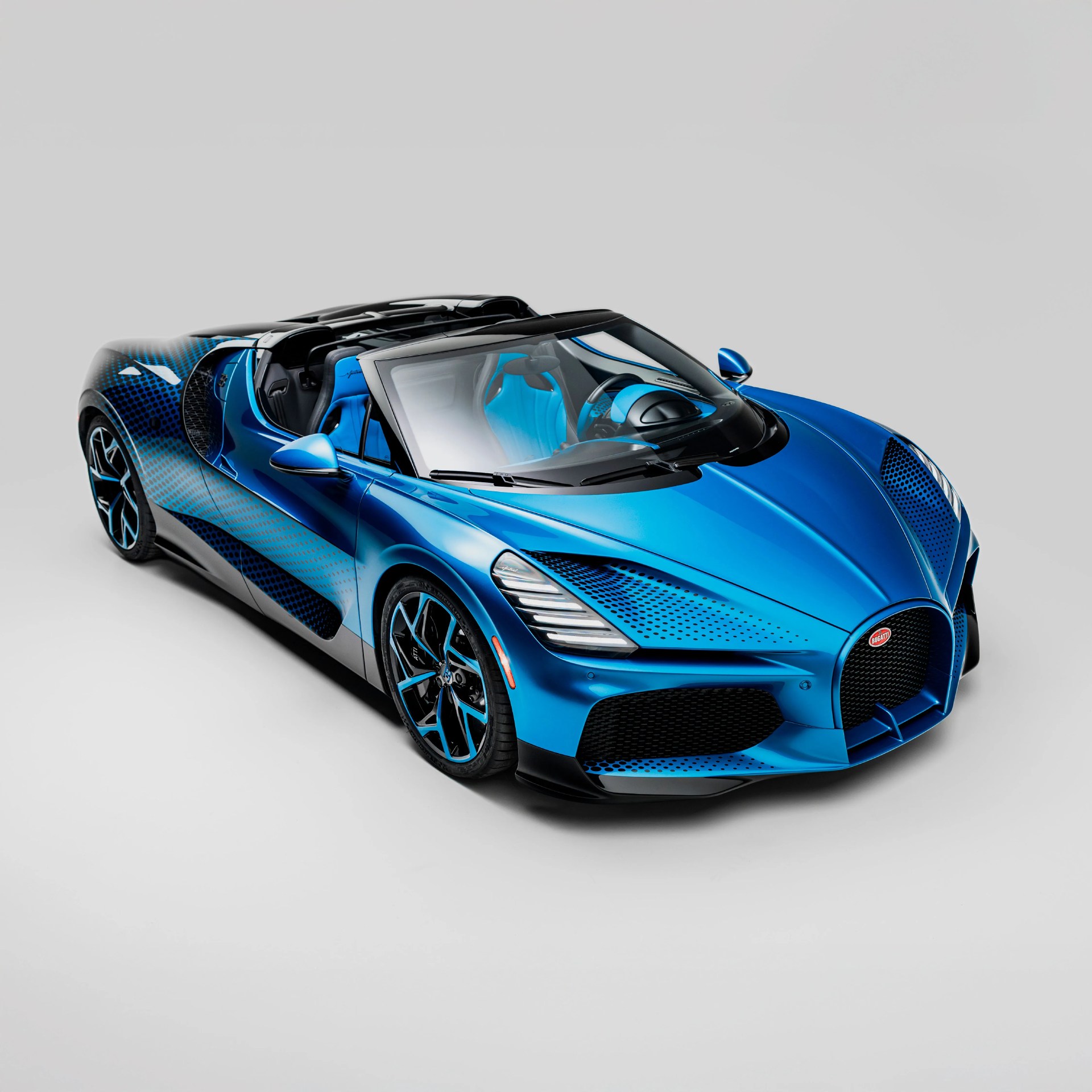 Blue and black Bugatti convertible sports car with blue interior seats and black rims.
