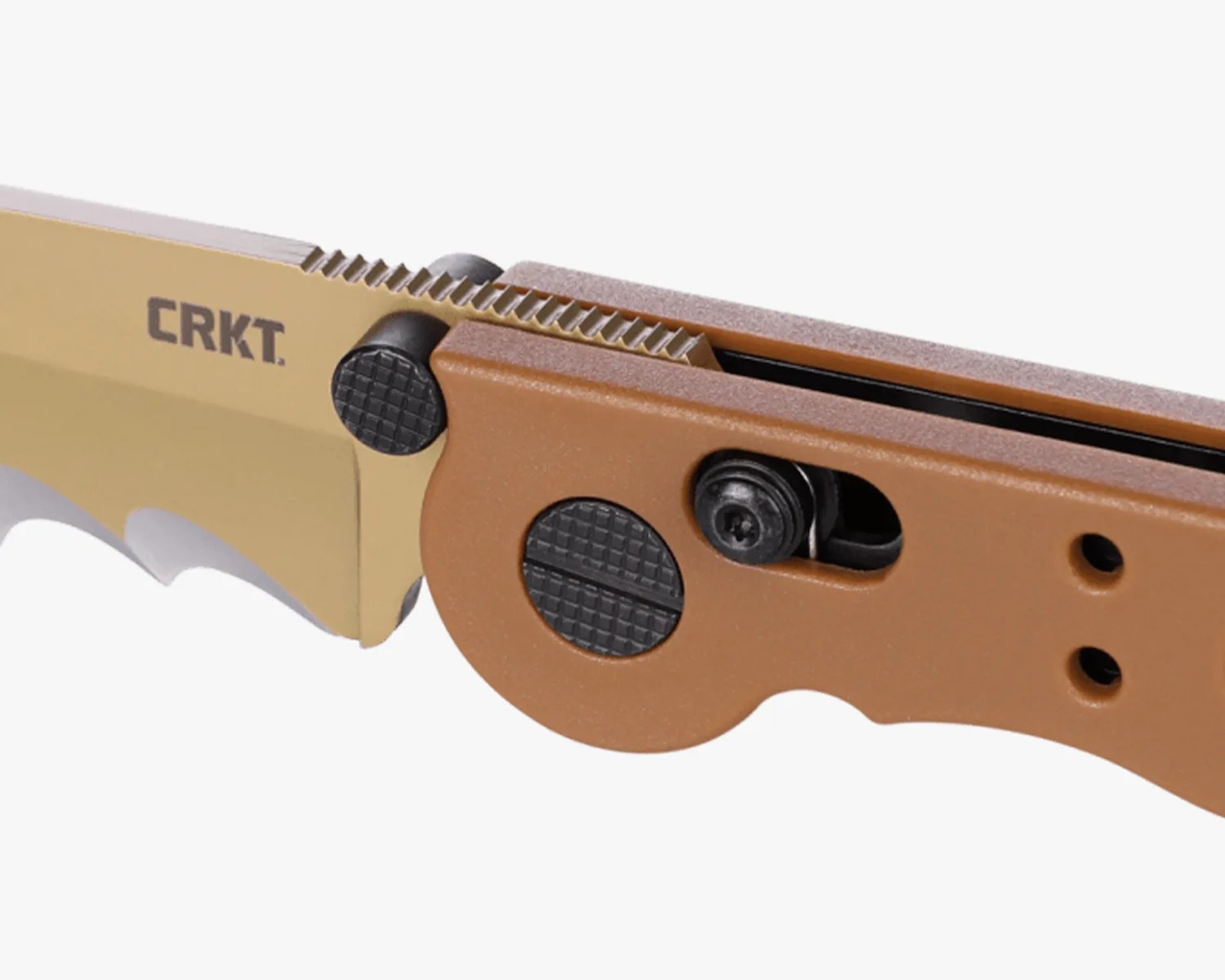 Close-up of a tan folding knife blade with serrated spine and brown handle featuring textured black buttons.