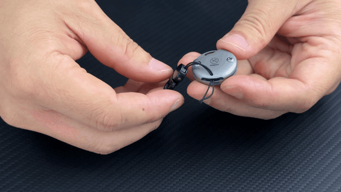 hands attaching lanyard to tiny multi-tool