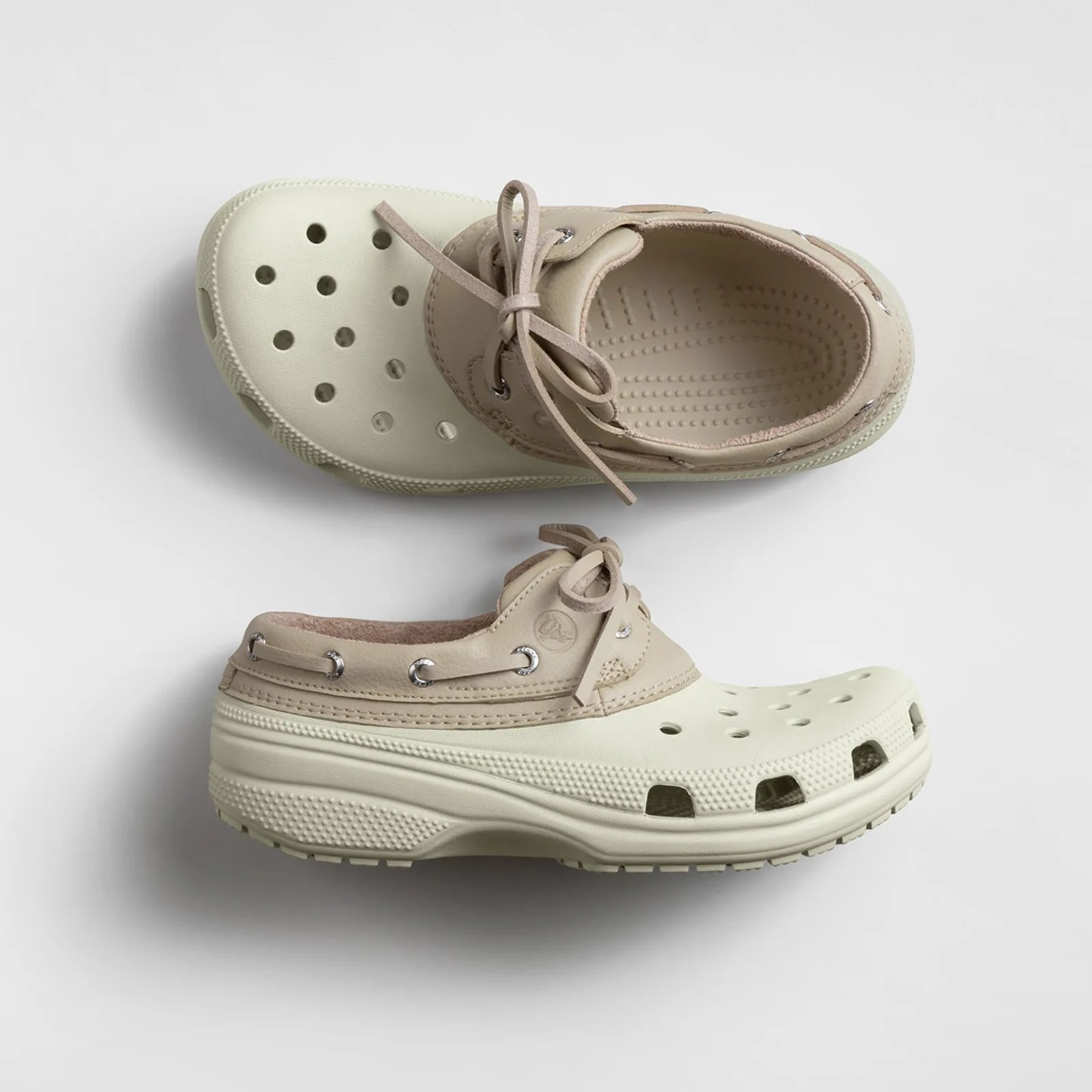 Beige and cream slip-on shoes with perforated toe box and lace-up leather collar.