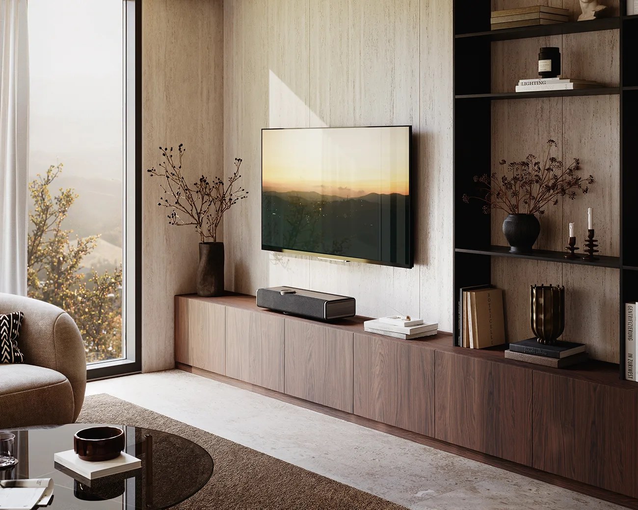 Living room with wall-mounted flat-screen TV above a long wooden cabinet, black shelving unit, and large window with beige sofa nearby.