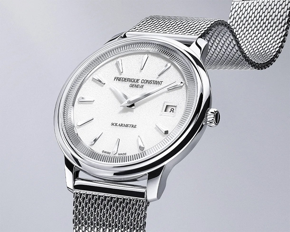 Silver Frederique Constant wristwatch with white textured dial, date window, and mesh metal strap.