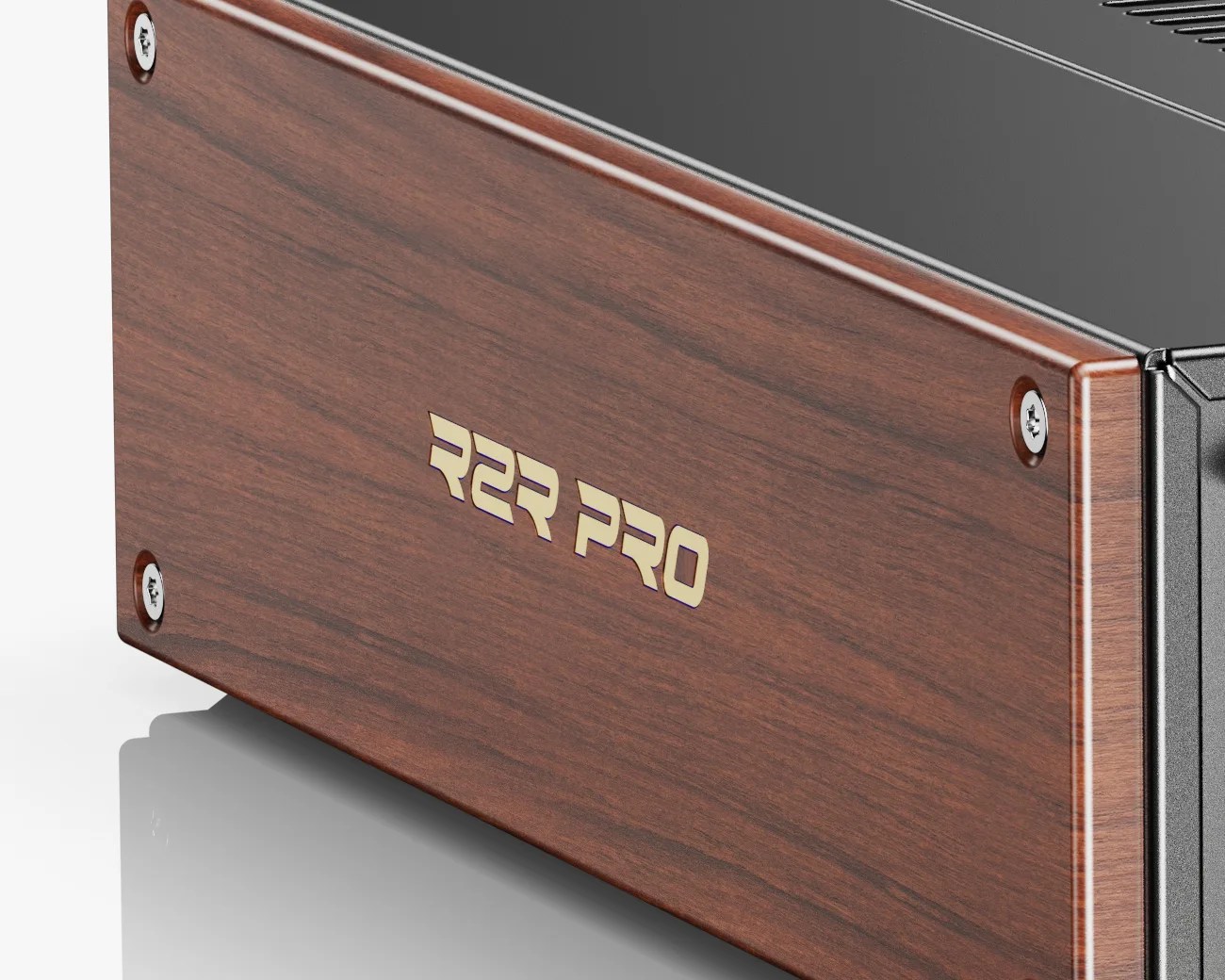 Close-up of a black device with a polished wood side panel engraved with "R2R PRO" in gold letters.