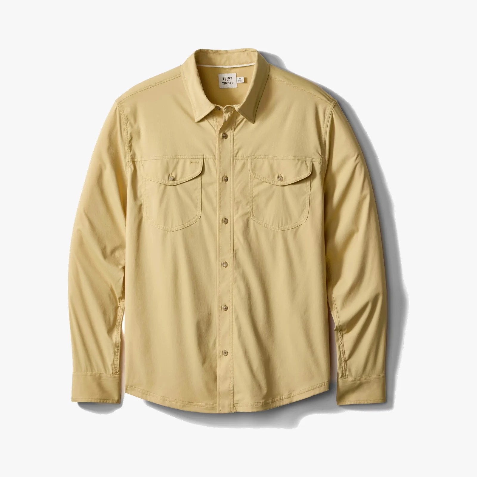 Light tan long-sleeve button-up shirt with two front buttoned chest pockets.