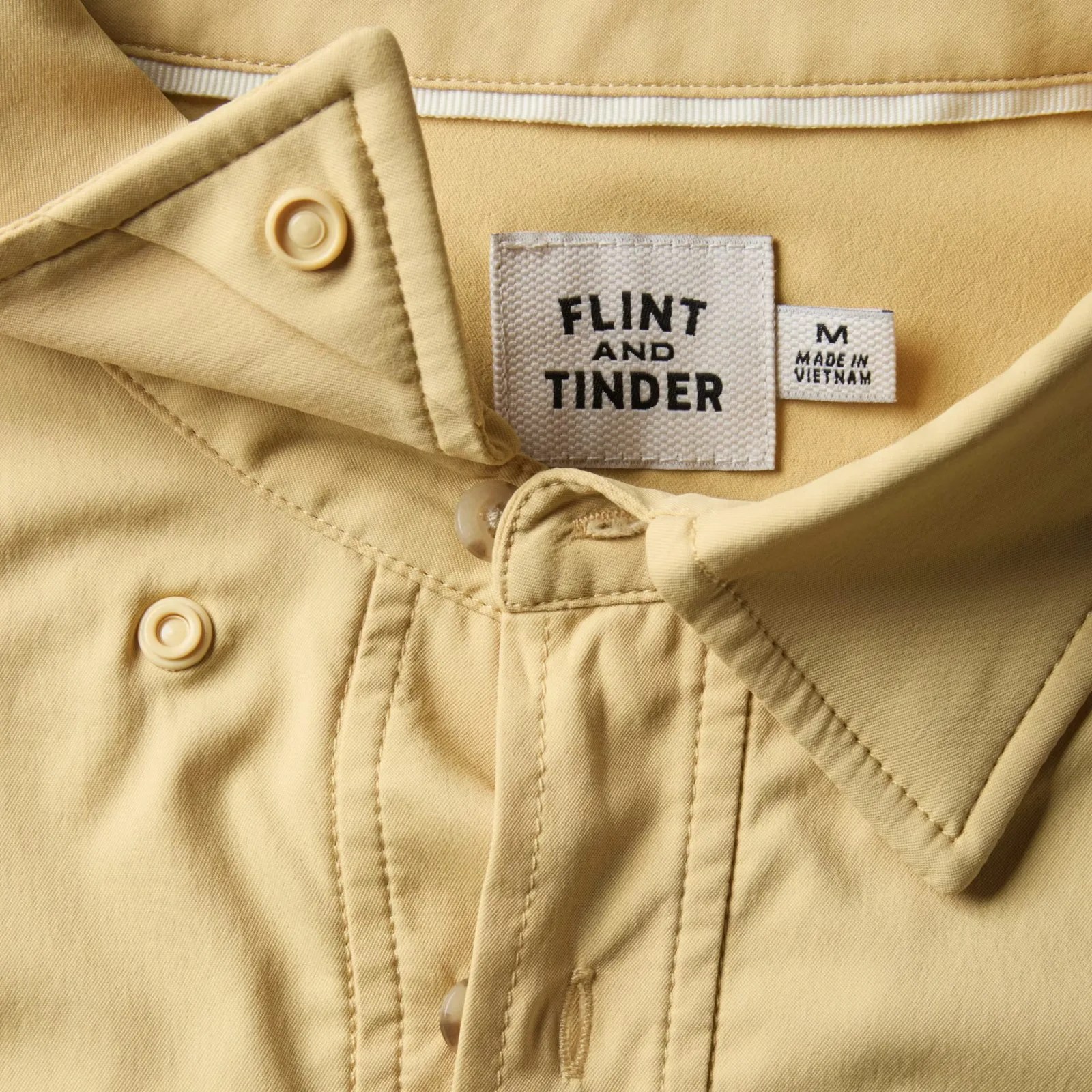 Beige shirt collar with beige buttons and a white fabric label reading "FLINT AND TINDER" and "M MADE IN VIETNAM.