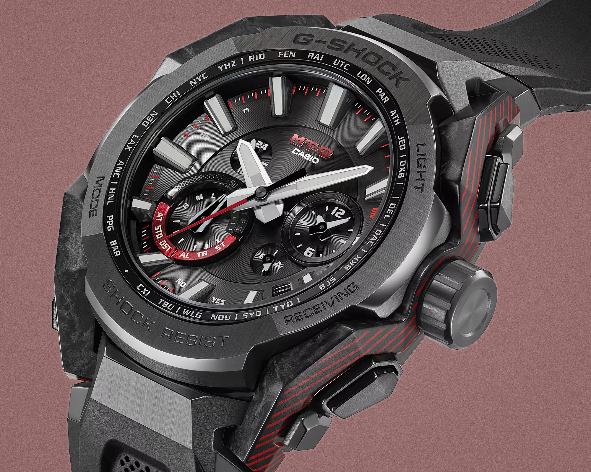 Black and silver Casio G-Shock MT-G analog watch with red accents and multiple dials on a mauve background.