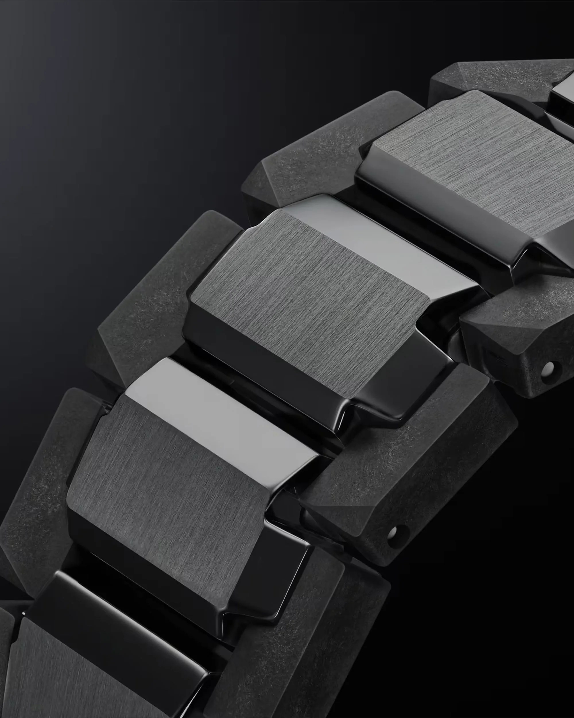 Close-up of a black and brushed metal watch band link on a dark background.