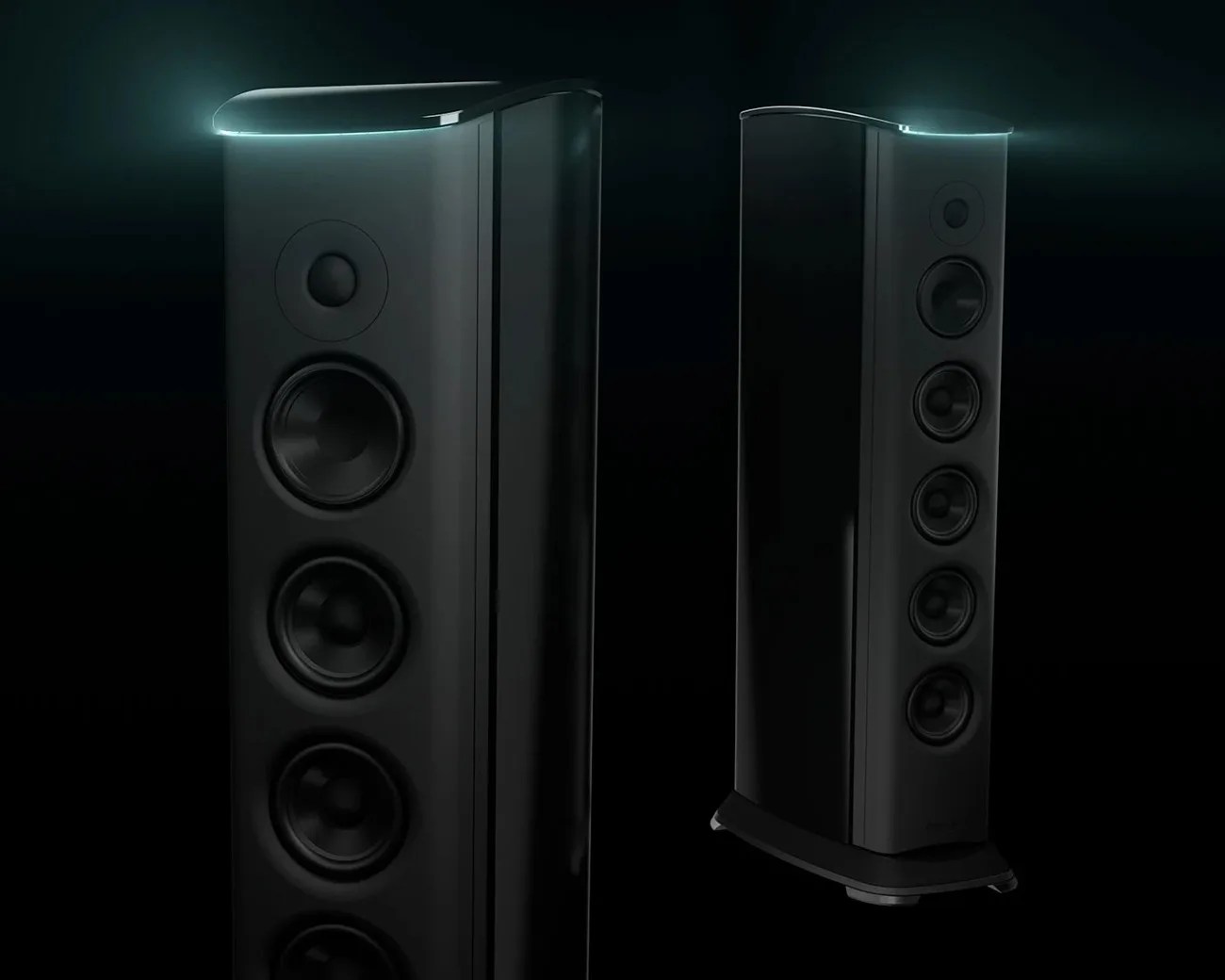 Two tall black floor-standing speakers with multiple drivers and curved tops illuminated by soft blue light.