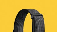 Black woven nylon watch strap with a black plastic loop on a yellow background.