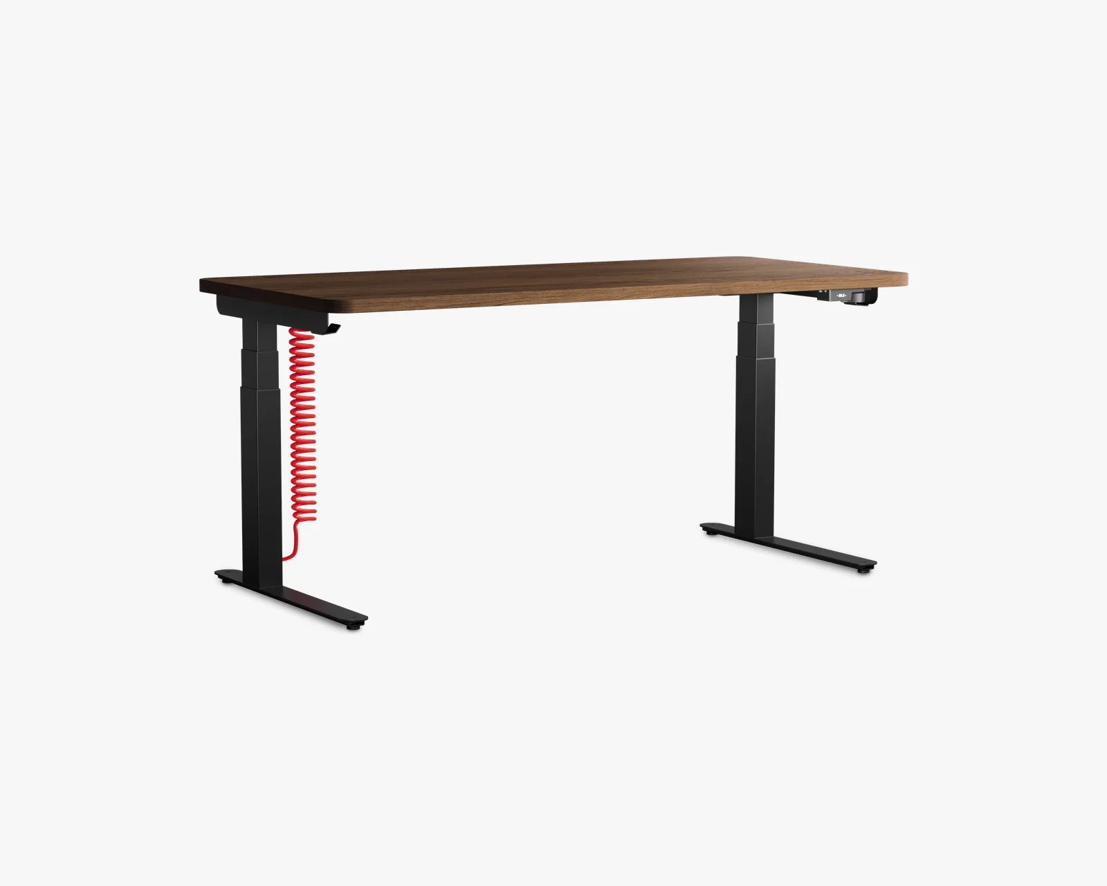 Adjustable standing desk with a walnut wood top and black metal legs with a red coiled cable.