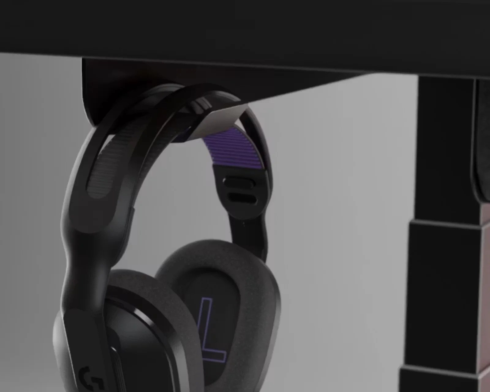 Black over-ear gaming headphones with purple inner headband hanging on a black metal stand.