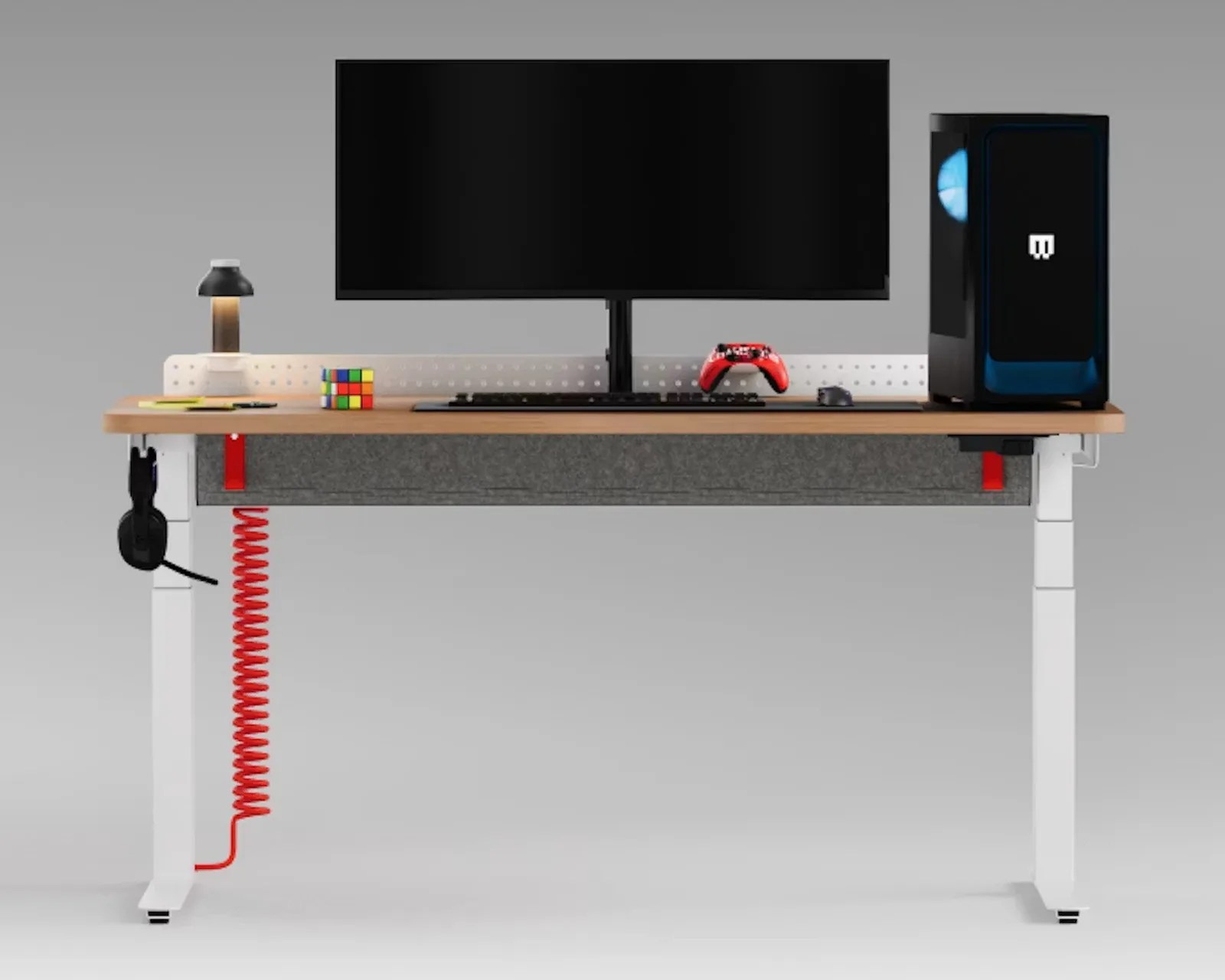 Standing desk setup with a large curved monitor, black keyboard, red game controller, black mouse, gaming PC tower, desk lamp, Rubik's cube, and headset hanging on the side.
