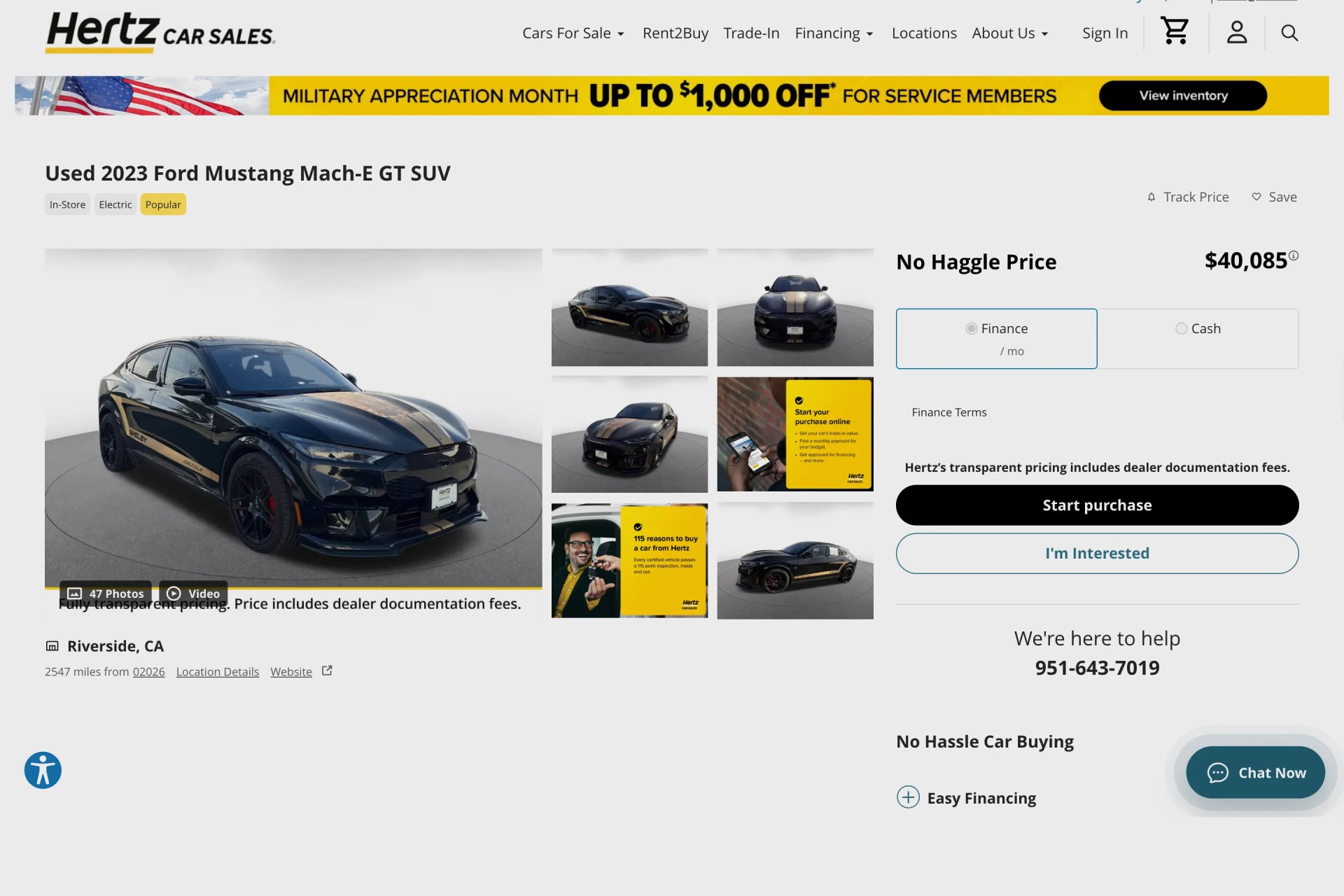 Black 2023 Ford Mustang Mach-E GT SUV with gold racing stripes and Shelby branding on display at Hertz Car Sales.
