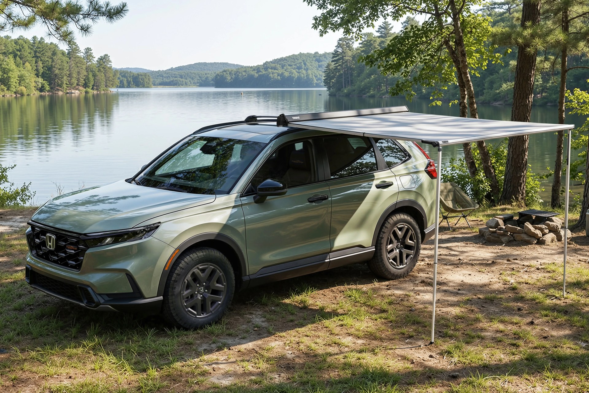 Light green Honda SUV with black roof rack and extended gray Thule awning parked by a lake with trees and a campfire ring nearby.