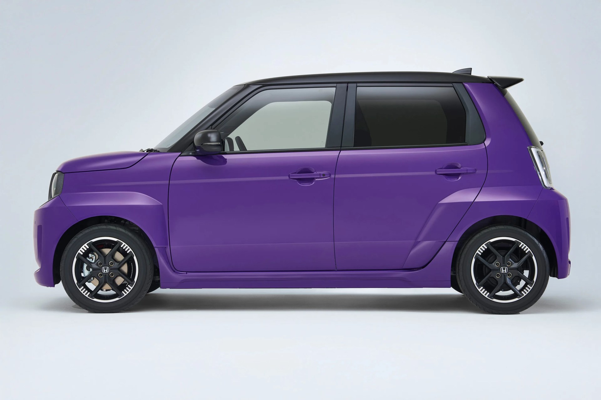 Purple compact hatchback car with black roof and black alloy wheels on a white background.