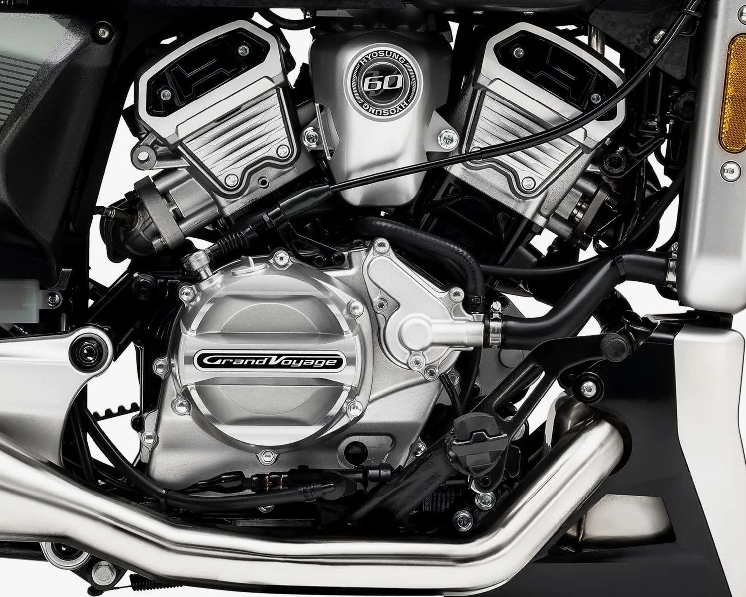 Close-up of a silver Hyosung Grand Voyage motorcycle engine with black and metallic components.