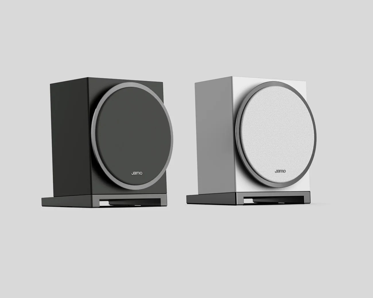 Pair of rectangular Jamo speakers, one black and one white, each with a circular front grille and a rectangular base.