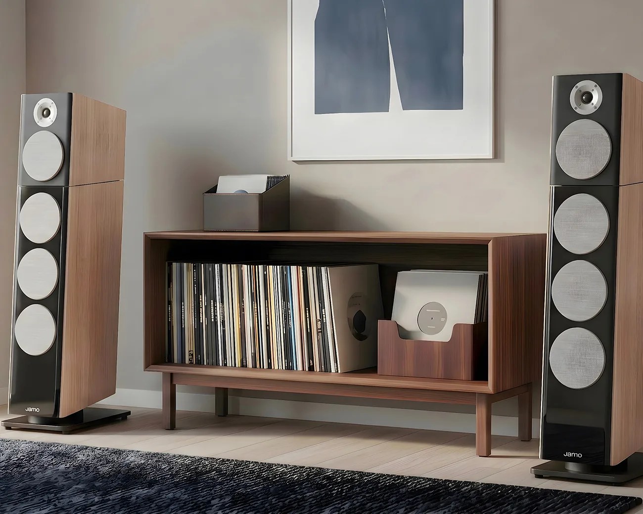 Pair of tall wooden floor-standing speakers with silver drivers flanking a wooden record shelf filled with vinyl records.