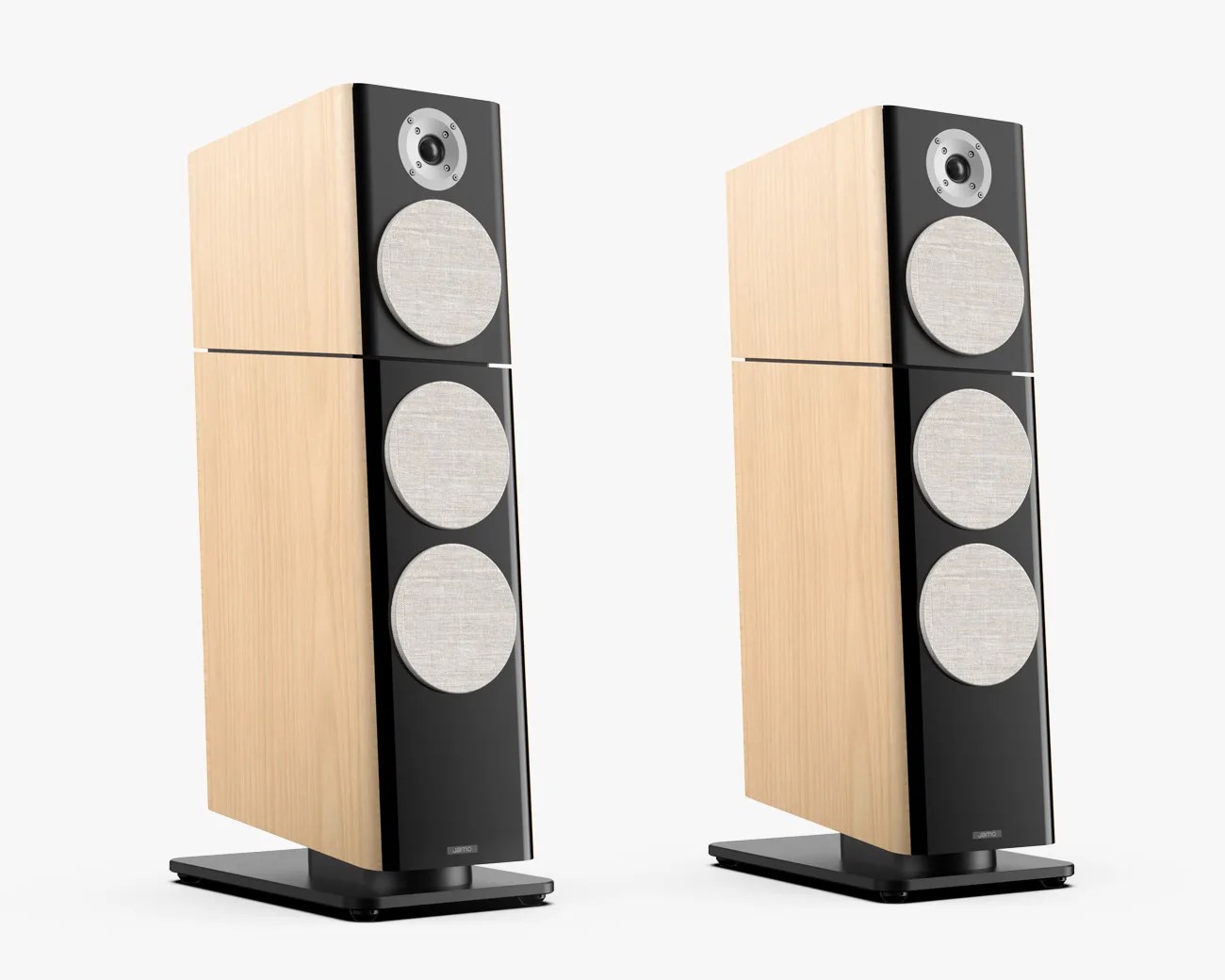 Pair of floor-standing speakers with light wood cabinets, black front panels, and three fabric-covered drivers each.