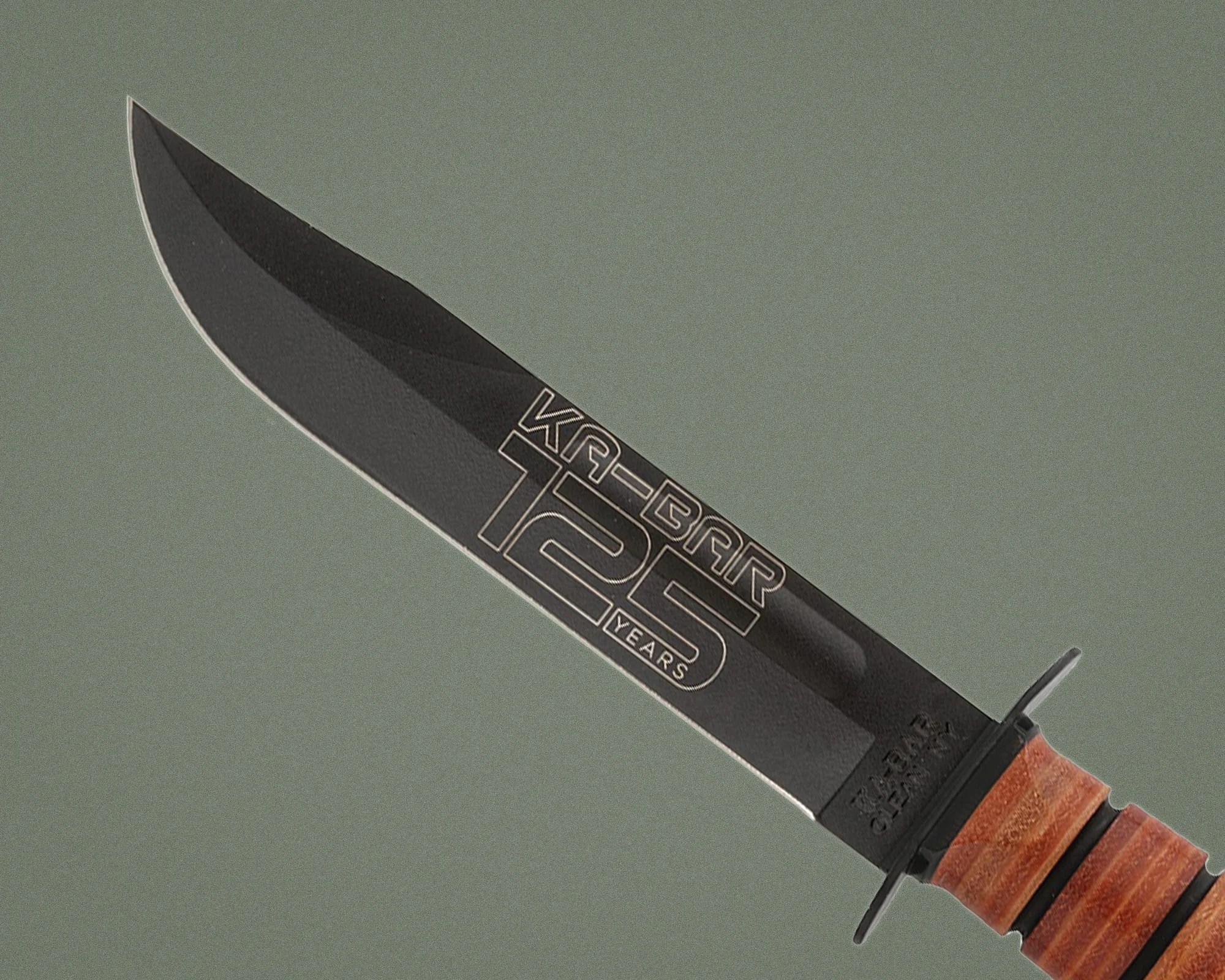 Black KA-BAR knife blade with "125 years" text and stacked leather handle on gray background.