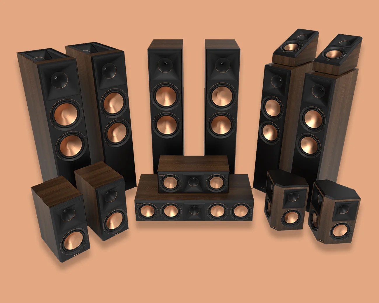 Set of multiple Klipsch speakers with black fronts, copper cones, and wood-finished cabinets on a tan background.